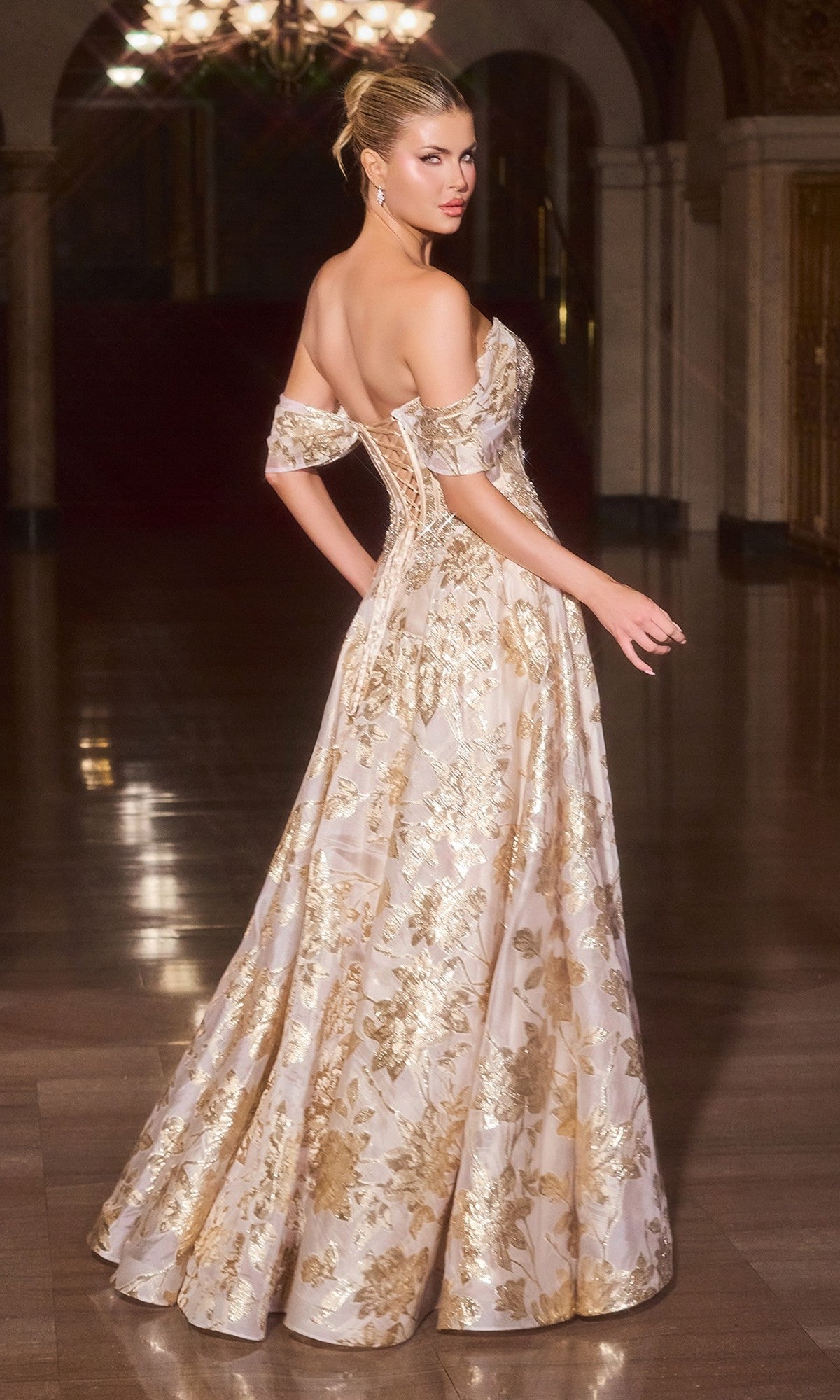A woman stands indoors looking over her shoulder, hair in an updo, wearing the elegant Ladivine CD682 Long Prom Dress—an off-the-shoulder metallic floral jacquard ball gown.